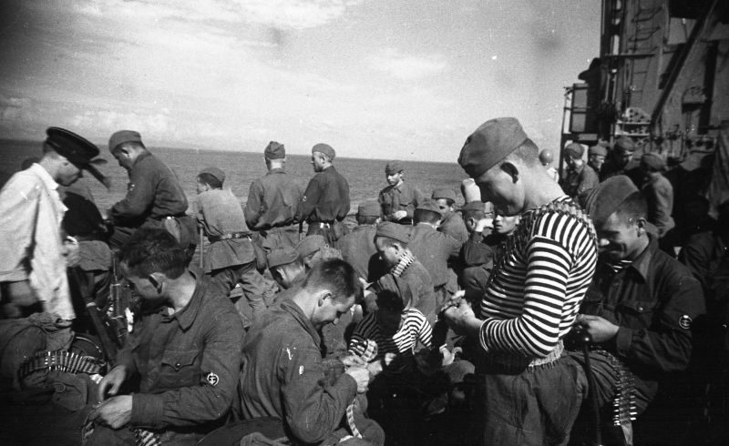 Бойцы морской пехоты Черноморского флота снаряжают пулеметные ленты на борту корабля. 1942 г. 
