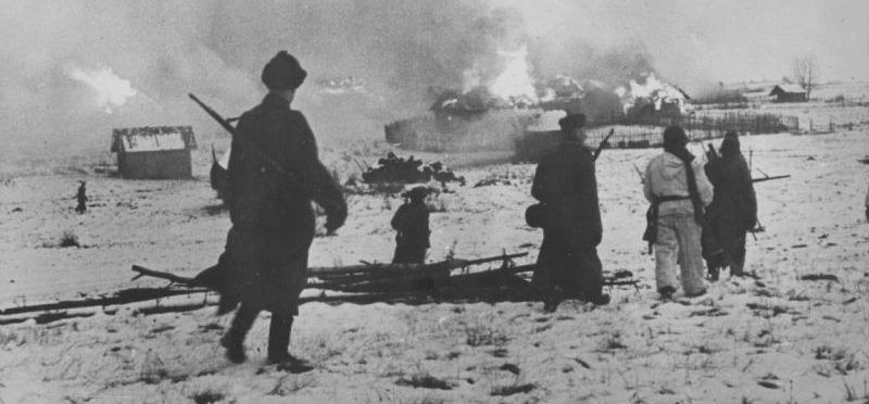 Эстонские добровольцы СС на улице горящей деревни в Псковской области во время операции против партизан. 1943 г. 