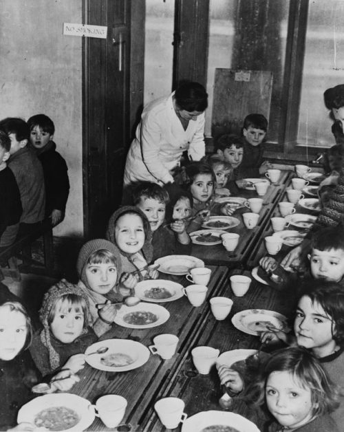 Английские дети, эвакуированные из западного Лондона, за обедом. Декабрь 1941 г.