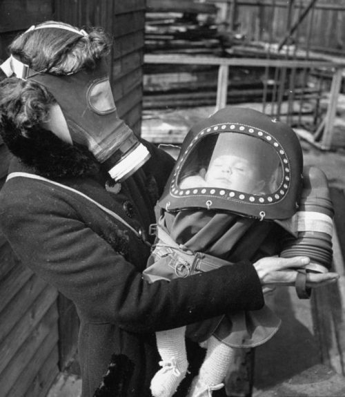 Жительница Лондона с ребенком во время испытания противогазов. 1941 г.