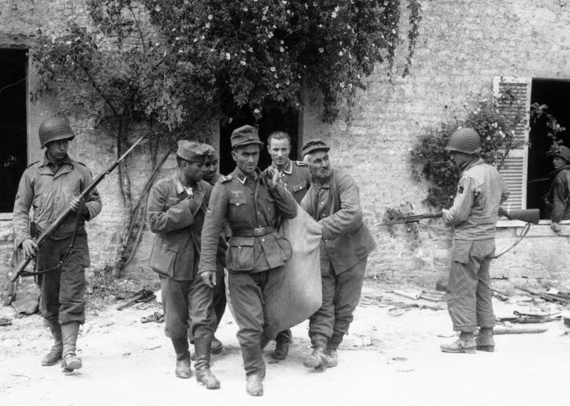 Пленные солдаты одного из грузинских батальонов вермахта несут раненого в Нормандии. Июнь 1944 г. 