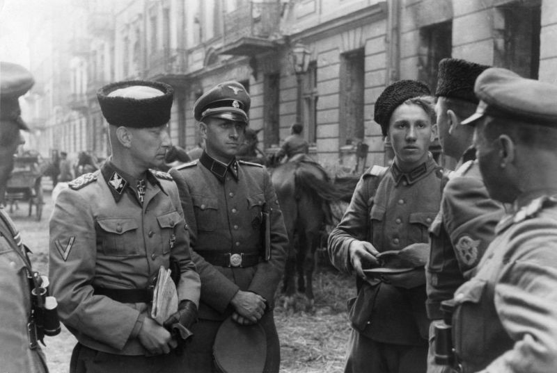 Группенфюрер СС Хайнц Райнефарт с солдатами казацкого подразделения Вермахта во время операции по подавлению Варшавского восстания. Август 1944 г. 