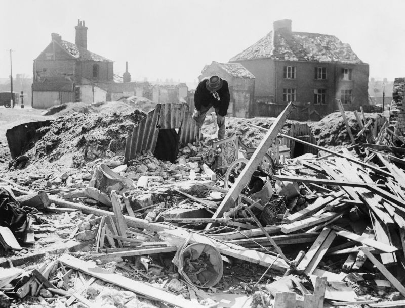 Житель британского Нориджа на развалинах дома. 1942 г. 