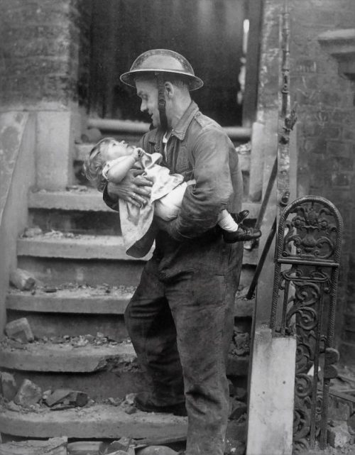 Спасатель с девочкой Барбарой Джеймс, вынесенной из разрушенного бомбами дома в Лондоне. 1944 г.