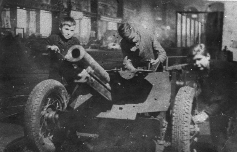 Дети за сборкой 76-мм полковой пушки на заводе в Молотове. 1943 г. 