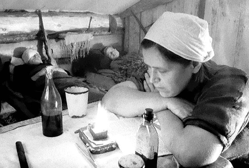 Медсестра партизанского отряда читает во время ночного дежурства. 1942 г.