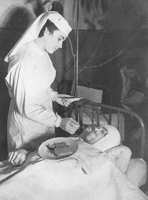 Медсестра Ленинградского Военно-морского госпиталя кормит раненого краснофлотца. 1942 г.