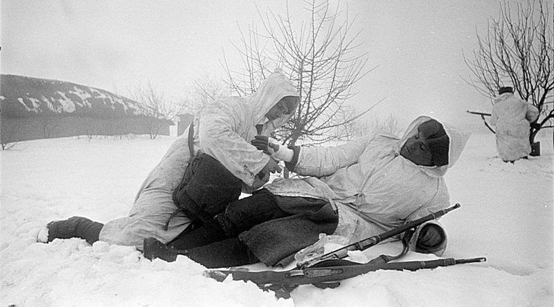 Санитар перевязывает раненого во время боя на Юго-Западном фронте. 1942 г. 