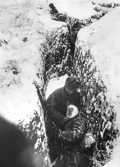 Санитар перевязывает раненого во время боя на Юго-Западном фронте. 1942 г.