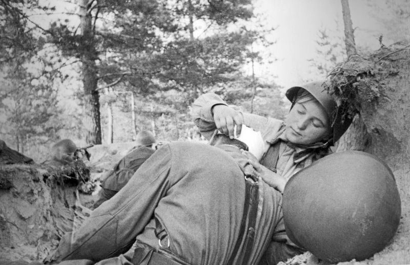 Санинструктор сержант Зоя Мураева перевязывает раненого на Волховском фронте. 1942 г. 