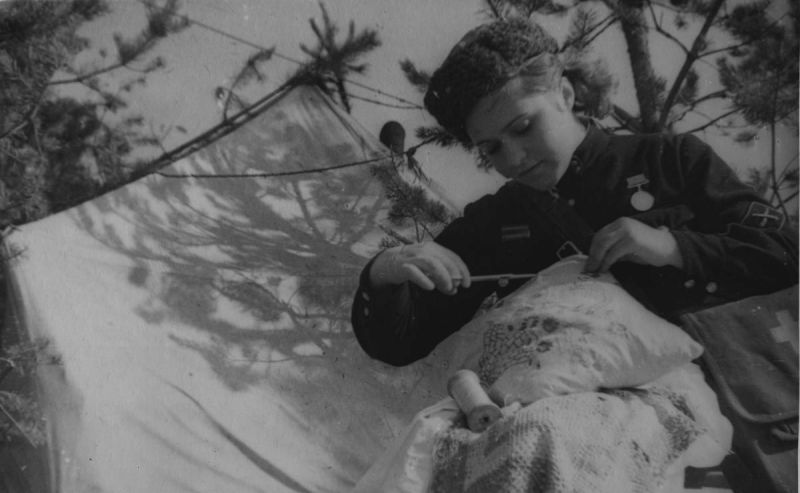 Старший военфельдшер Евгения Зубакова вышивает в часы затишья. Ленинградский фронт, апрель 1943 г. 