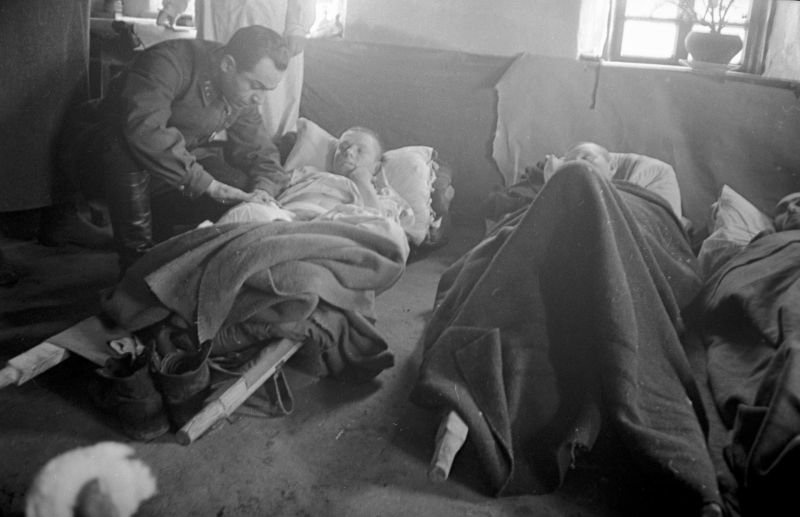 Военврач осматривает раненого в полевом госпитале. Степной фронт. Август 1943 г. 