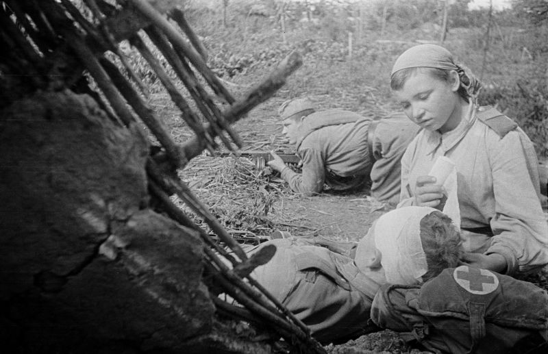 Санинструктор перевязывает раненого командира взвода на Нежинском направлении. Постановочное фото. 1943 г. 