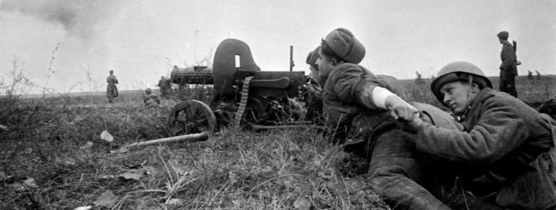 Санинструктор перевязывает руку пулеметчику. Постановочное фото. Декабрь 1944 г. 