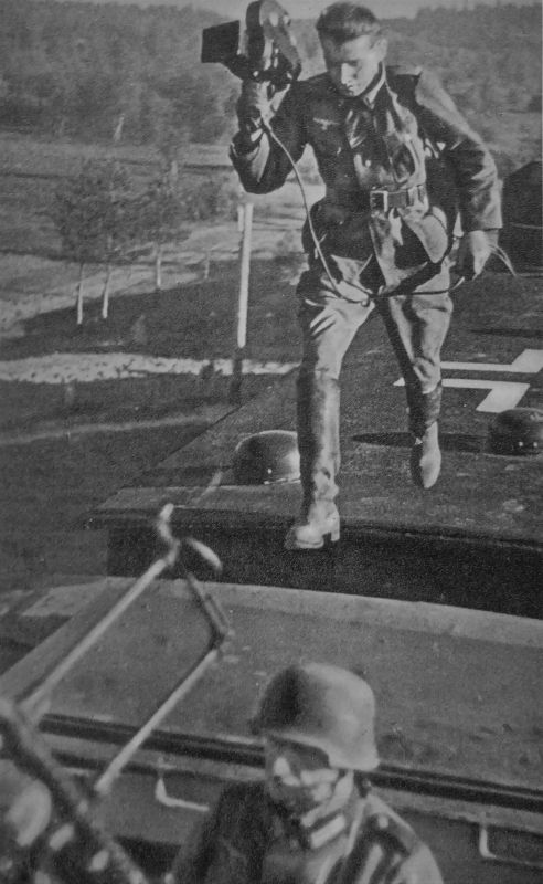 Немецкий военный кинооператор в прыжке между вагонами бронепоезда. 1941 г. 