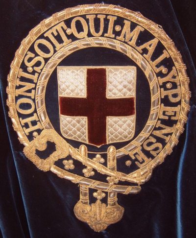 Знак Ордена, вышитый на левом плече рыцарской бархатной мантии синего цвета.