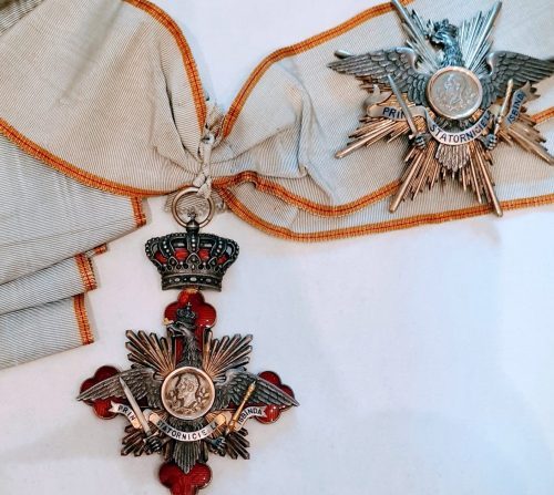 Знак ордена Кароля I со звездой Большого креста на шейной ленте.