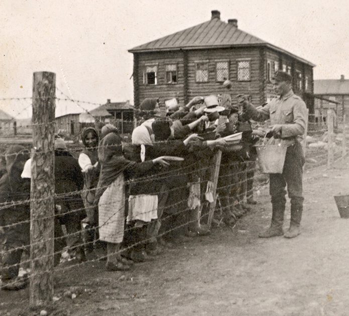 Финский солдат раздает еду лагерным детям. 1942 г.