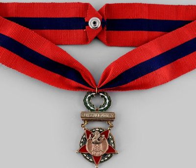 Орденская планка и медаль «Звезда выдающегося поведения» на шейной ленте.