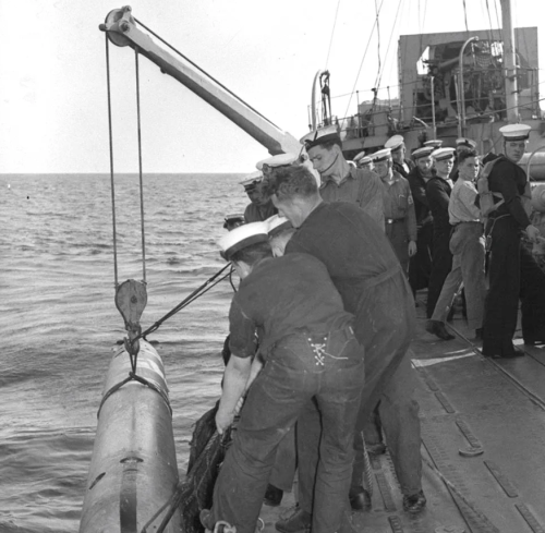 Матросы поднимают учебную торпеду на борт HMCS Ottawa. 1940 г.