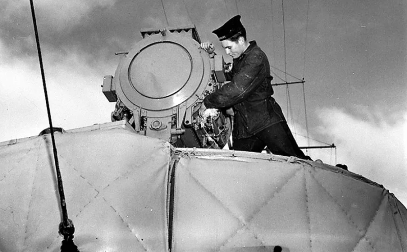 Матрос чистит прожектор на борту HMCS Assiniboine. 1940 г.