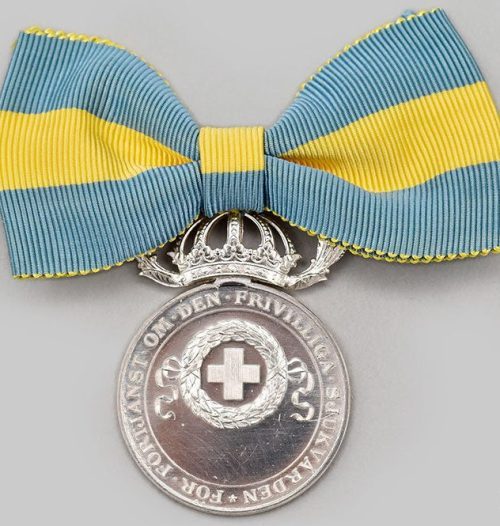 Аверс и реверс серебряной медали Красного Креста за заслуги в добровольном медицинском обслуживании женщин II степени.