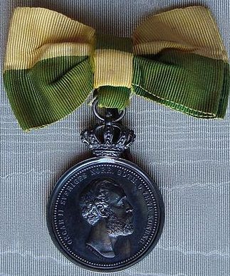 Серебряная медаль «За долгую верную службу» Королевского патриотического общества на женском банте.