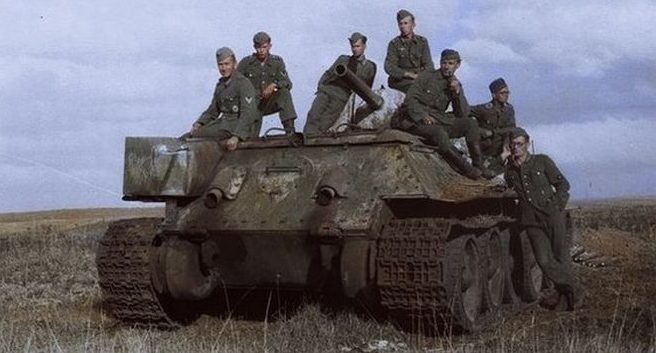 Немецкие солдаты на советском среднем танке Т-34, брошенном в Белгородской области. 1941 г.