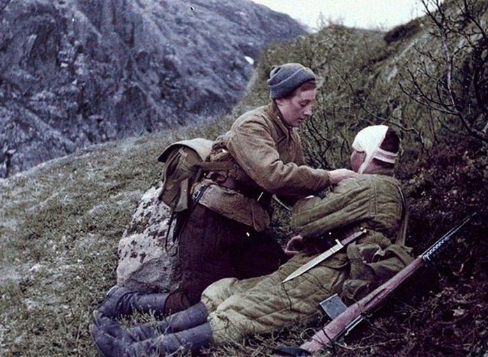 Сандружинница перевязывает раненого бойца на поле боя. Кавказ 1943 г. 