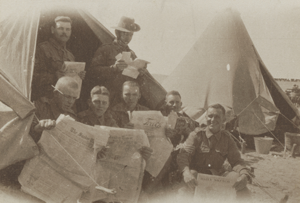 Австралийские солдаты читают почту возле палатки в Египте.