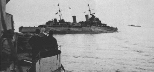 HMS Nigeria накренился после попадания торпеды.