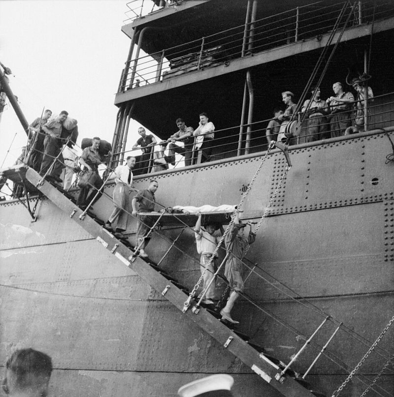 Раненого моряка выносят на носилках с борта судна «Мельбурн Стар» на Мальте. Август 1942 г.